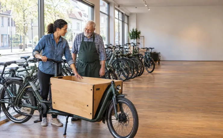 Nachfolgerin eines Fahrradladens legt fest, wo die Lastenräder künftig stehen, der langjährige Inhaber hört zu