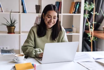 Dein Studium an der EHiP Junge Frau arbeitet am Laptop und lächelt